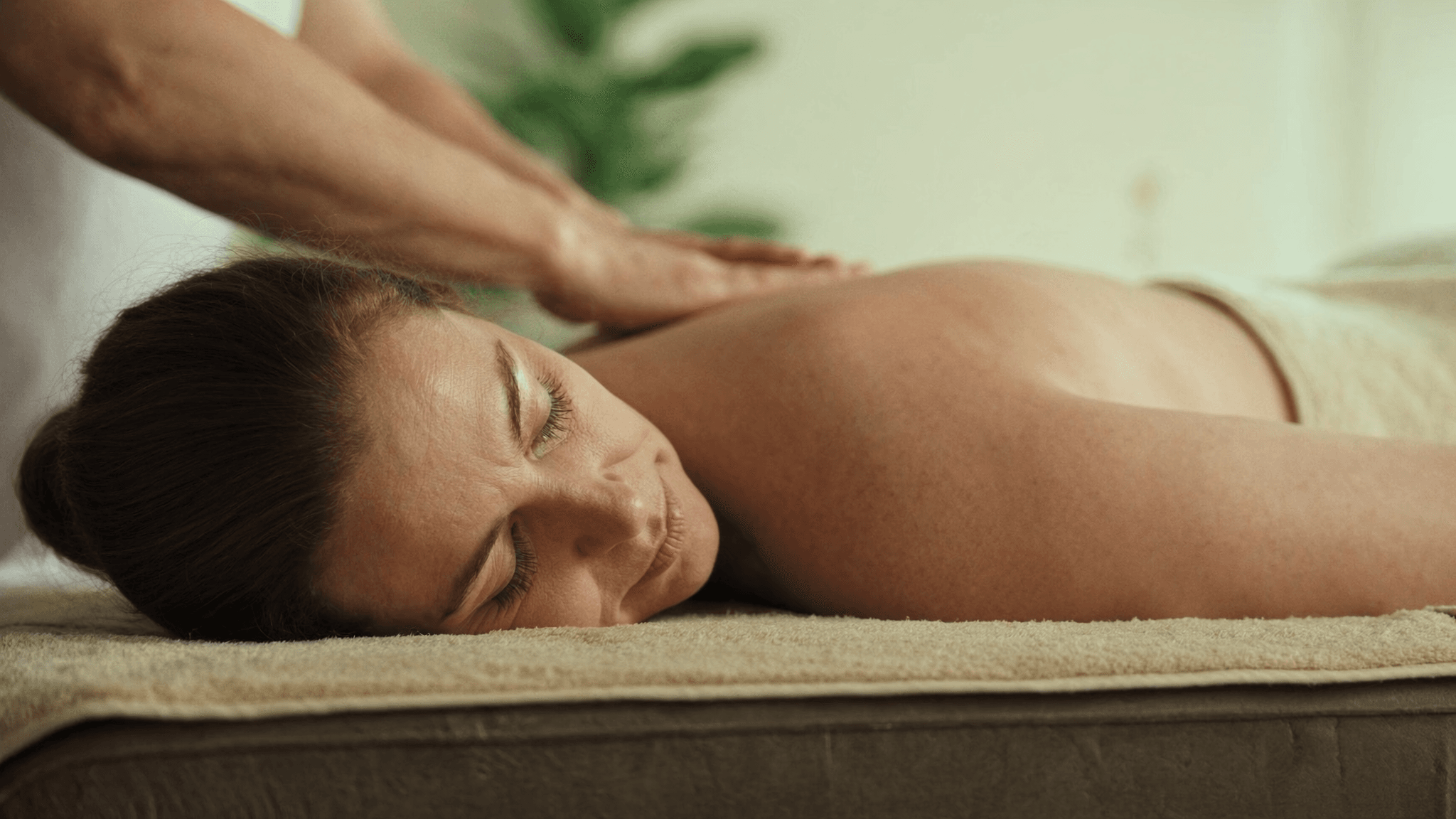 Woman relaxing on a massage table, illustrating how often you should get a massage for wellbeing