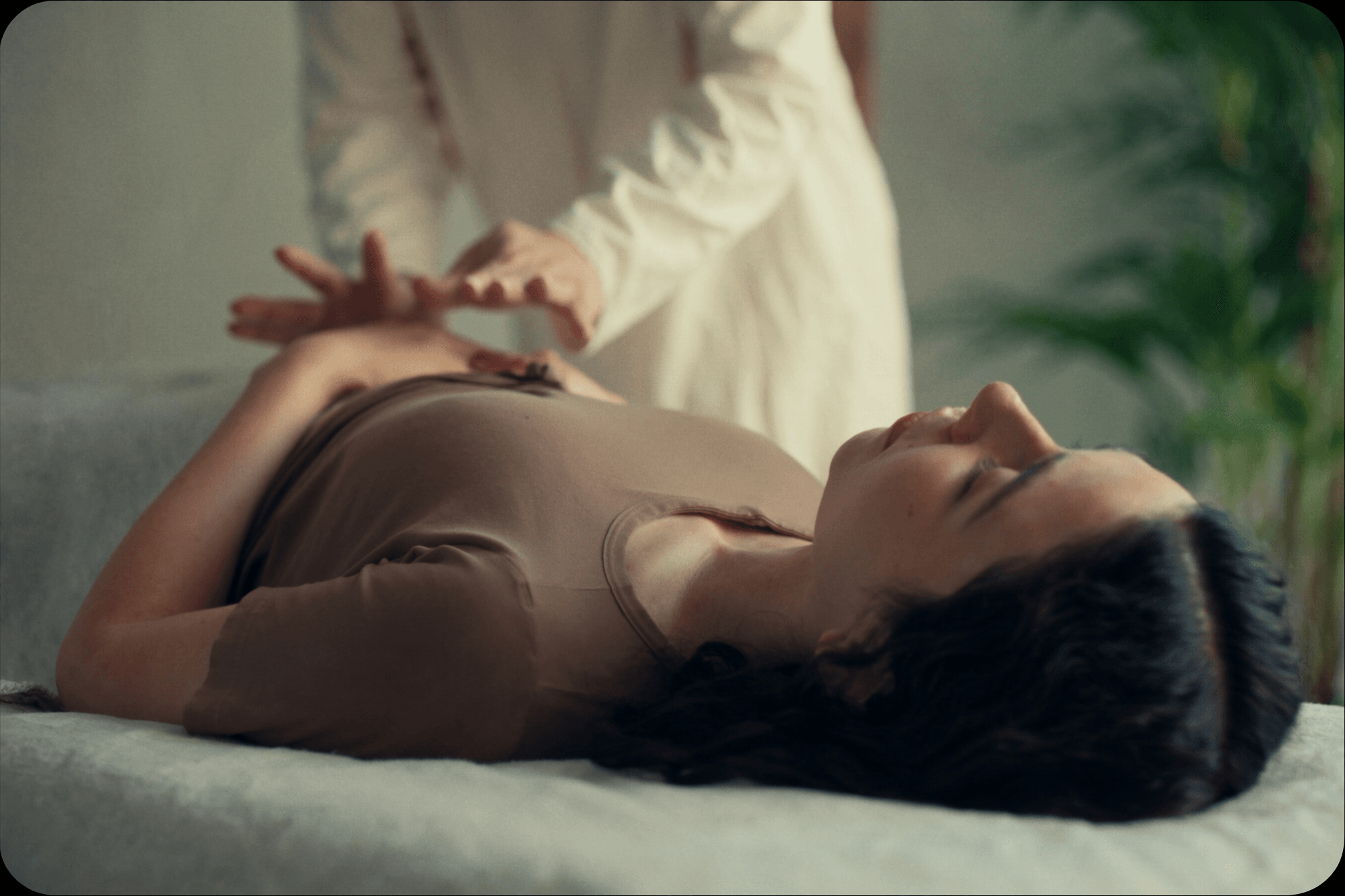 Practitioner's hands resting gently above a relaxed client during a calm reiki treatment session.