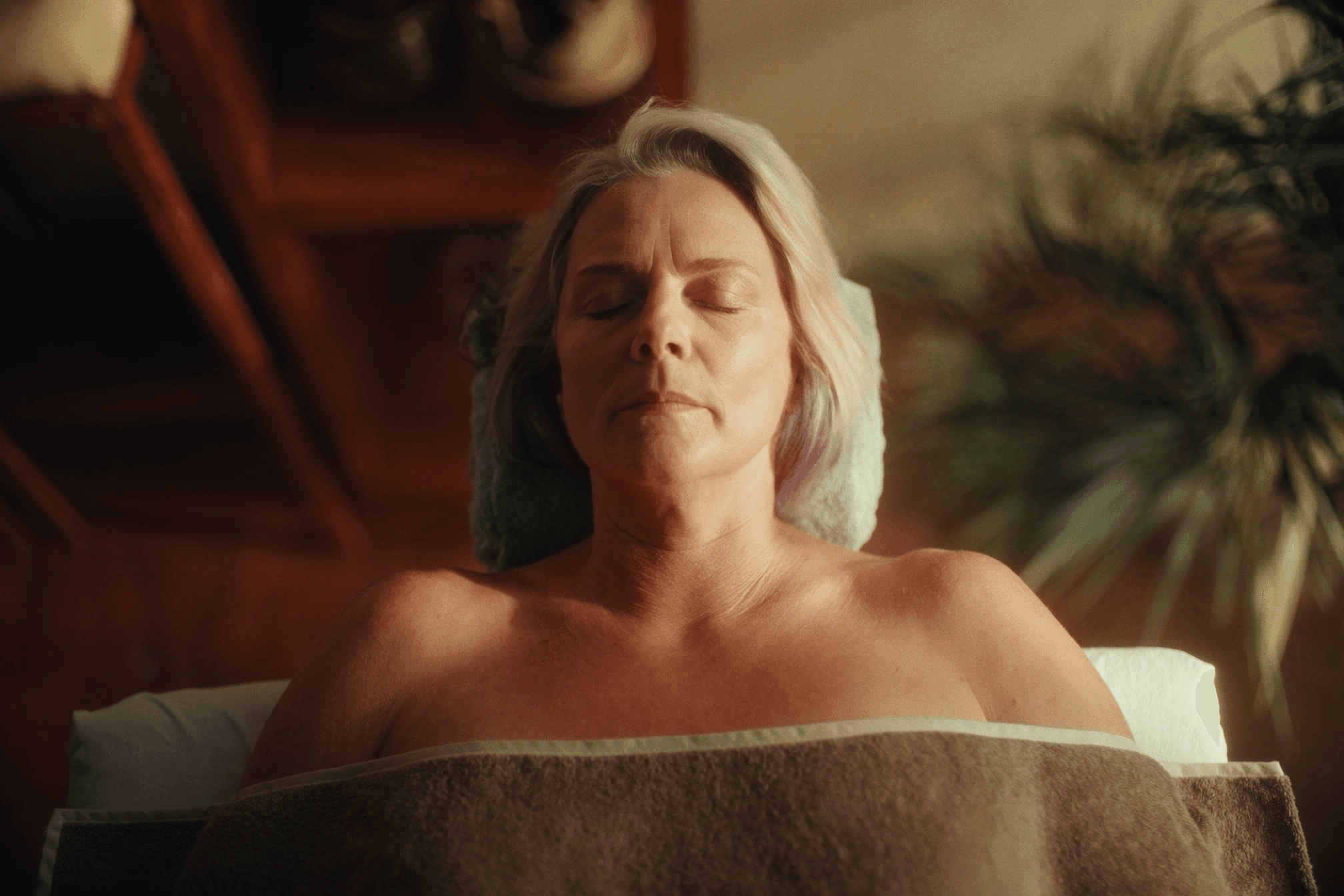 Woman in her 50s relaxing during a recovery massage after strength training for women over 40